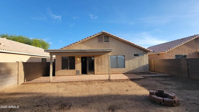 6784 W Gardenia Ave, Glendale, AZ 85303 - back of house featuring a fire pit, a fenced backyard, stucco siding, a patio area, and a tiled roof