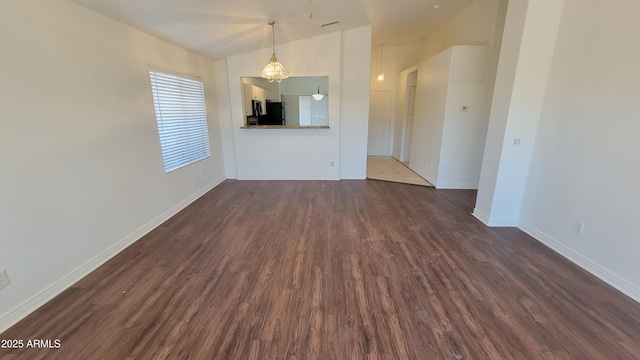 6784 W Gardenia Ave, Glendale, AZ 85303 - unfurnished living room with baseboards, dark wood finished floors, and visible vents
