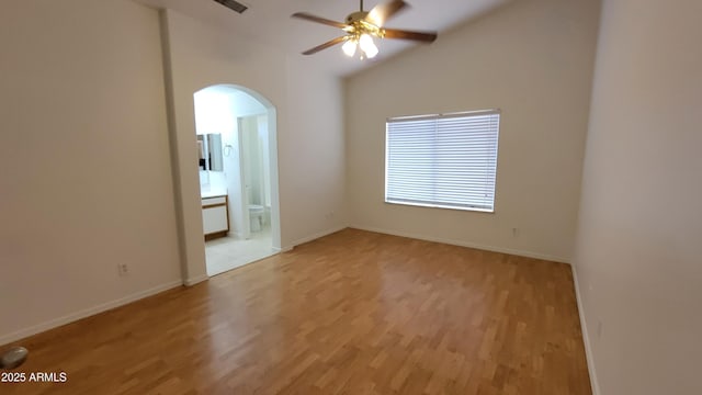 6784 W Gardenia Ave, Glendale, AZ 85303 - spare room with a ceiling fan, baseboards, arched walkways, light wood finished floors, and vaulted ceiling