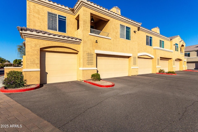 view of front of house featuring a garage and a balcony