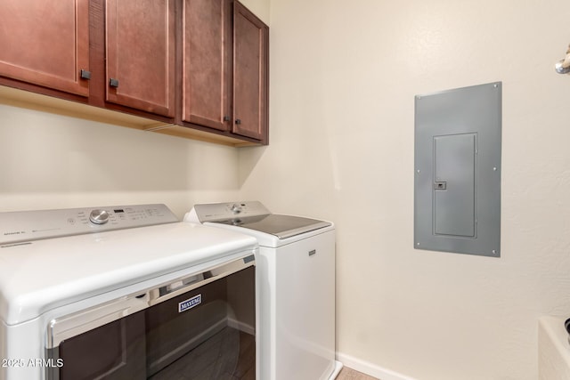 laundry area featuring washer and clothes dryer, cabinets, and electric panel