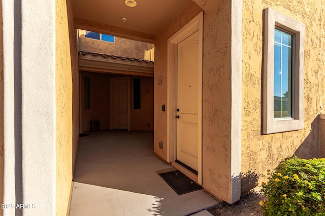 view of exterior entry with a patio