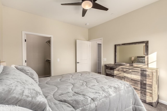 carpeted bedroom featuring a spacious closet, a closet, and ceiling fan