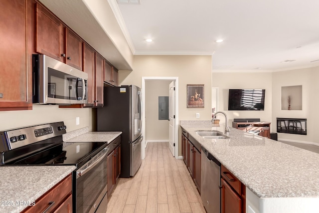 kitchen featuring light stone countertops, appliances with stainless steel finishes, sink, ornamental molding, and light wood-type flooring