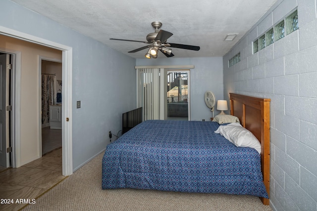 carpeted bedroom featuring a textured ceiling and ceiling fan