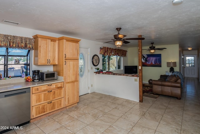 kitchen with appliances with stainless steel finishes, light brown cabinets, a textured ceiling, and ceiling fan