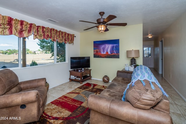 tiled living room with a textured ceiling and ceiling fan