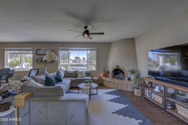 living room featuring ceiling fan, a fireplace, and a wealth of natural light