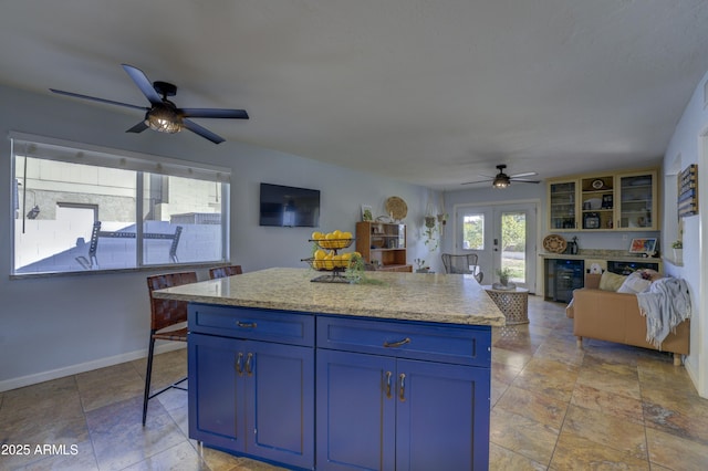 kitchen with a center island, french doors, blue cabinets, wine cooler, and ceiling fan