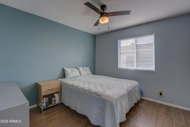 bedroom with dark hardwood / wood-style flooring and ceiling fan