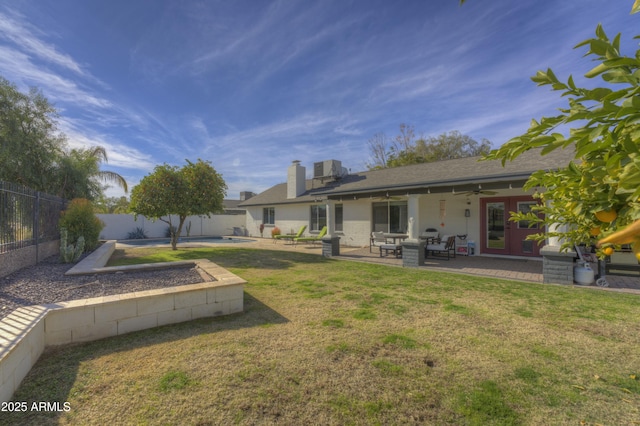 view of yard featuring french doors, ceiling fan, and a patio area