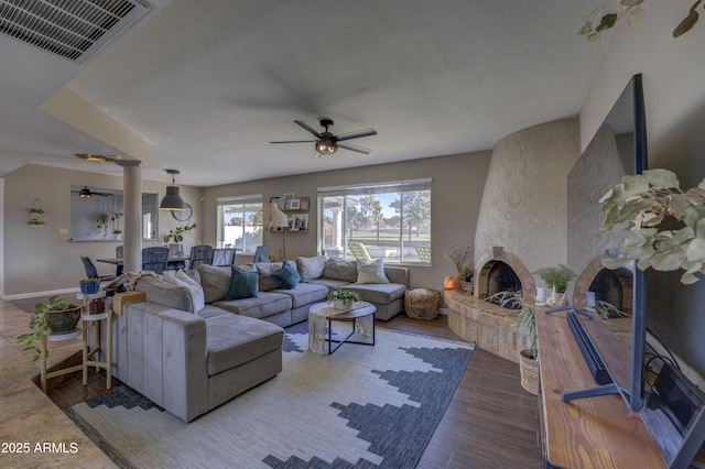 living room with ceiling fan, a fireplace, and hardwood / wood-style flooring