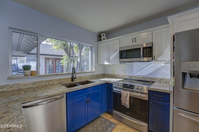 kitchen with blue cabinets, sink, light stone countertops, white cabinetry, and stainless steel appliances