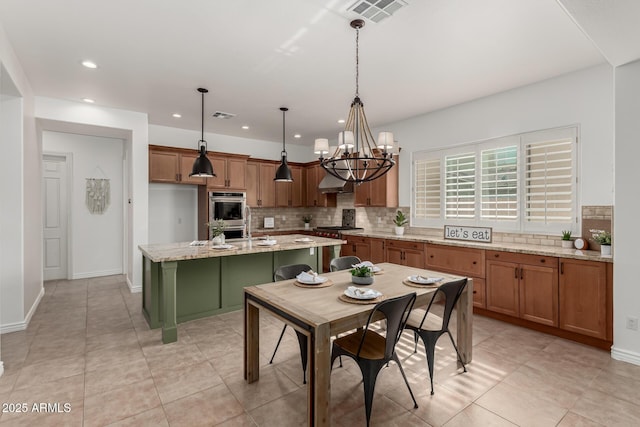 13204 W Palo Verde Dr, Litchfield Park, AZ 85340 - kitchen with a chandelier, brown cabinets, decorative backsplash, recessed lighting, and stainless steel appliances