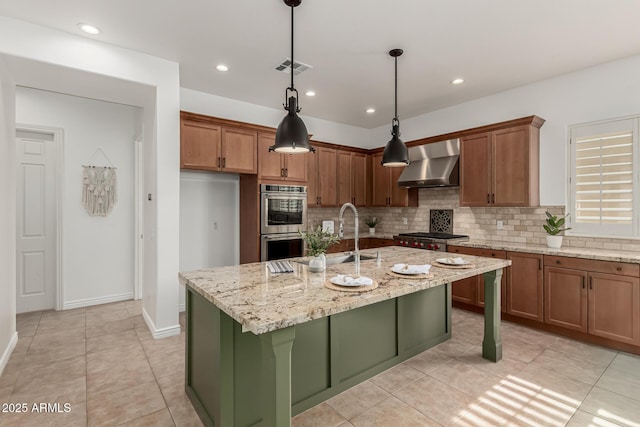 13204 W Palo Verde Dr, Litchfield Park, AZ 85340 - kitchen with wall chimney exhaust hood, stainless steel double oven, decorative backsplash, brown cabinetry, and recessed lighting
