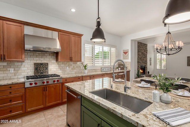 13204 W Palo Verde Dr, Litchfield Park, AZ 85340 - kitchen featuring stainless steel gas cooktop, a sink, backsplash, a chandelier, and wall chimney range hood