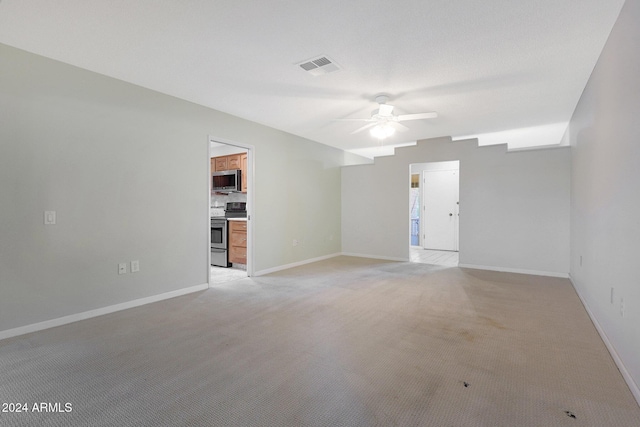 spare room featuring ceiling fan and light colored carpet