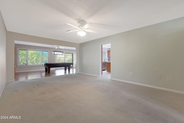 interior space featuring ceiling fan, light colored carpet, a textured ceiling, and billiards