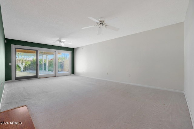 carpeted empty room with ceiling fan and a textured ceiling