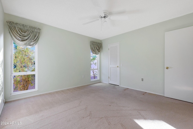 unfurnished room featuring ceiling fan and light colored carpet