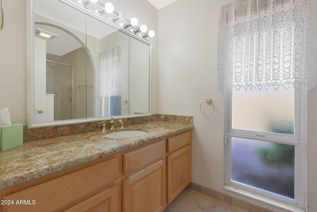 bathroom featuring tile patterned floors, vanity, and a shower with door