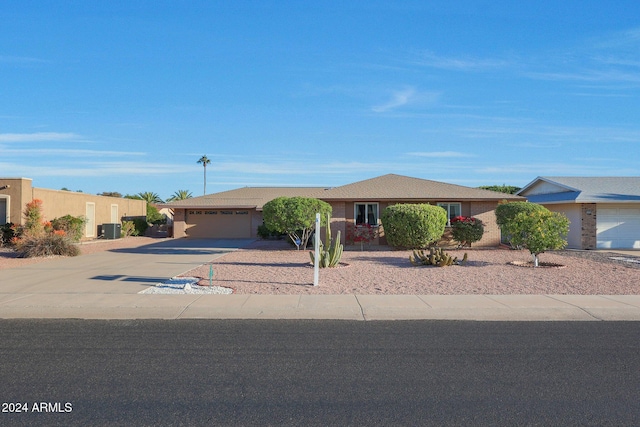 ranch-style home featuring a garage and central AC unit