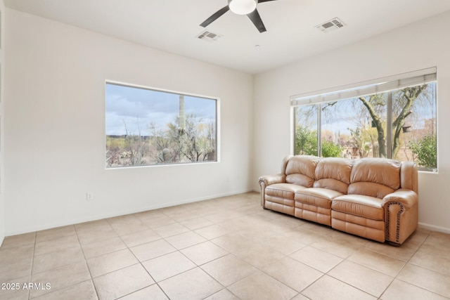 sitting room with light tile patterned floors, a ceiling fan, visible vents, and baseboards