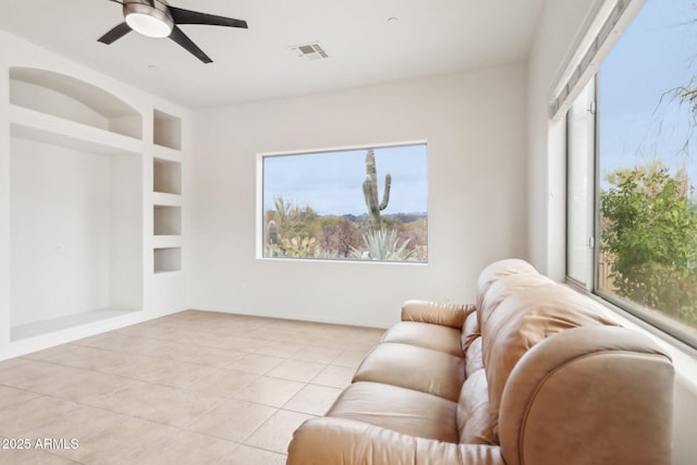 living room with light tile patterned flooring, built in features, a healthy amount of sunlight, and visible vents