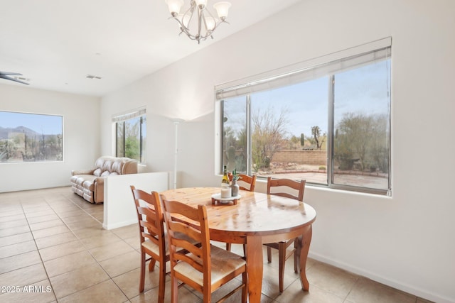 dining room featuring light tile patterned floors, baseboards, visible vents, and a chandelier
