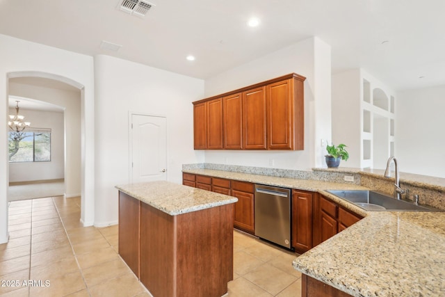 kitchen featuring visible vents, a sink, light stone countertops, arched walkways, and stainless steel dishwasher