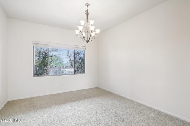 carpeted spare room with a chandelier and baseboards