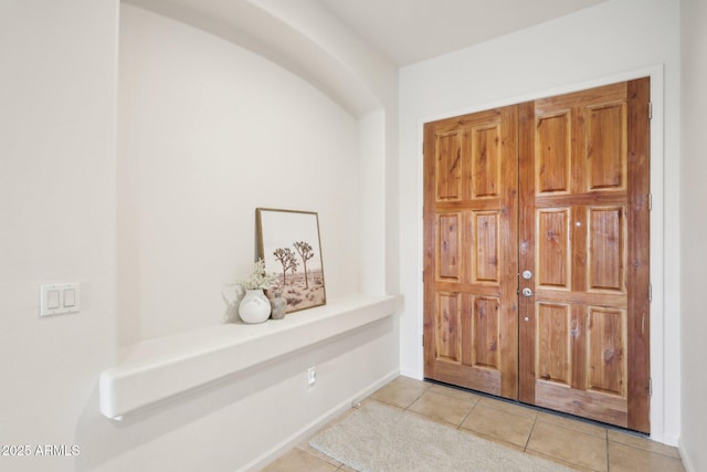 foyer with light tile patterned floors and baseboards