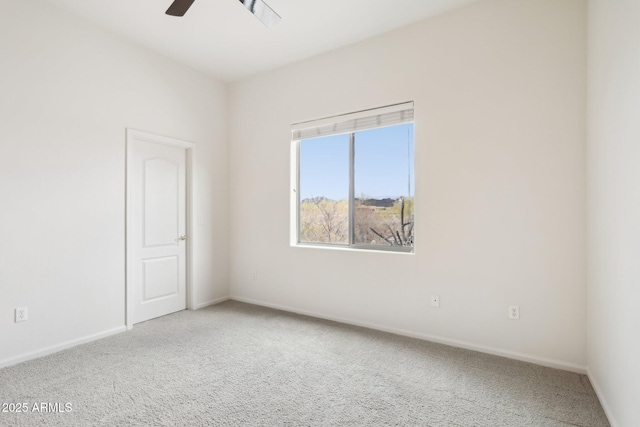 carpeted spare room with baseboards and ceiling fan