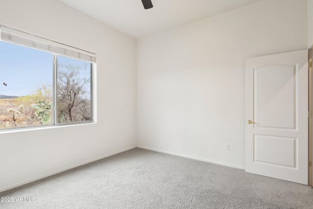 spare room featuring baseboards, a ceiling fan, and carpet