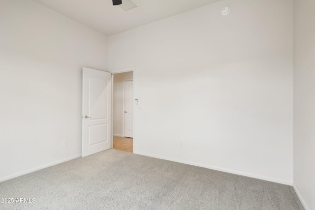 unfurnished room with baseboards, light carpet, visible vents, and a ceiling fan