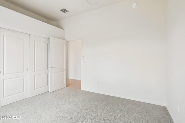 unfurnished bedroom featuring carpet, visible vents, a closet, and baseboards