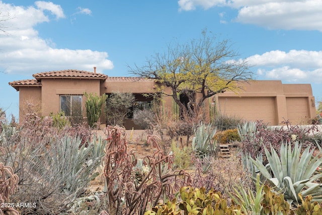 view of front facade featuring a tiled roof and stucco siding