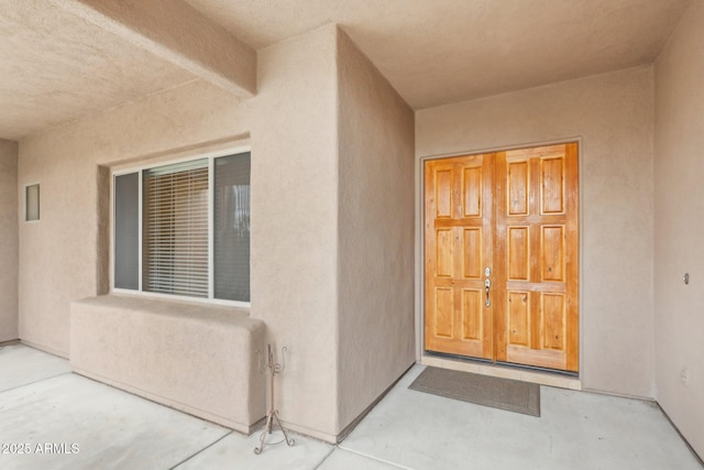 view of exterior entry featuring stucco siding