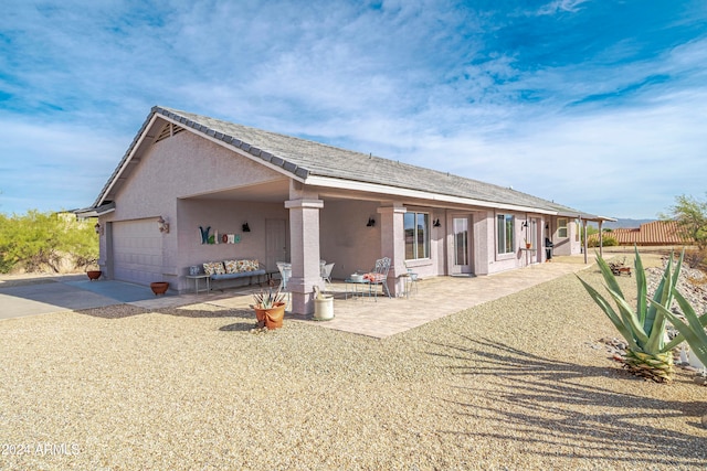 back of house featuring a garage and a patio area