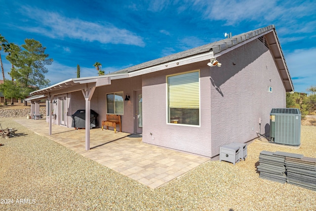 rear view of house with a patio area and central AC