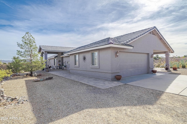 360 Bonita Dr, Wickenburg, AZ 85390 - view of property exterior with concrete driveway, a garage, a tile roof, and stucco siding