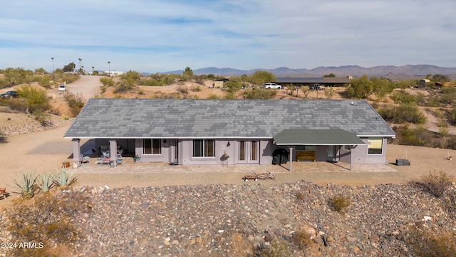 rear view of house with a mountain view and a patio