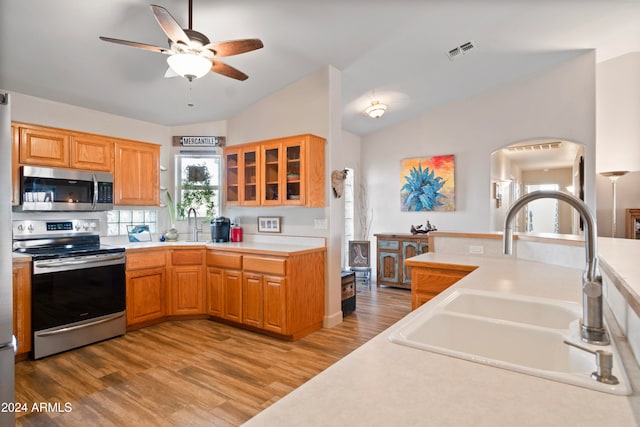 kitchen featuring ceiling fan, sink, lofted ceiling, appliances with stainless steel finishes, and light wood-type flooring