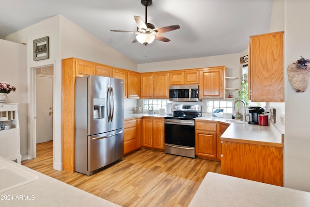 kitchen featuring ceiling fan, sink, light hardwood / wood-style flooring, lofted ceiling, and appliances with stainless steel finishes