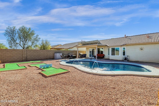 view of swimming pool with pool water feature and a patio