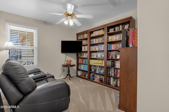 living area featuring ceiling fan and carpet