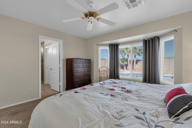 carpeted bedroom with ceiling fan and multiple windows