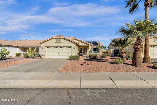 single story home featuring a garage and solar panels