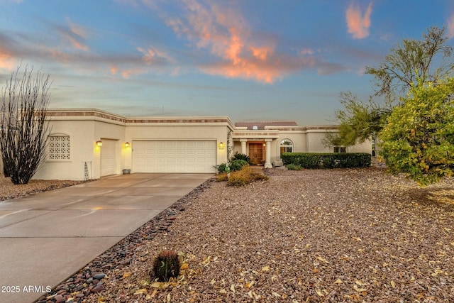 view of front of property with a garage, driveway, and stucco siding