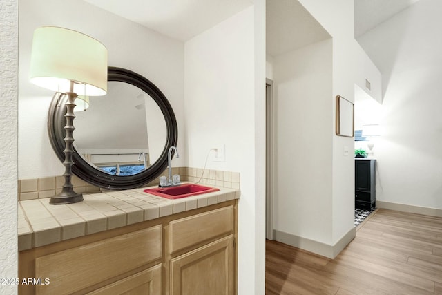 bathroom with visible vents, wood finished floors, vanity, and baseboards